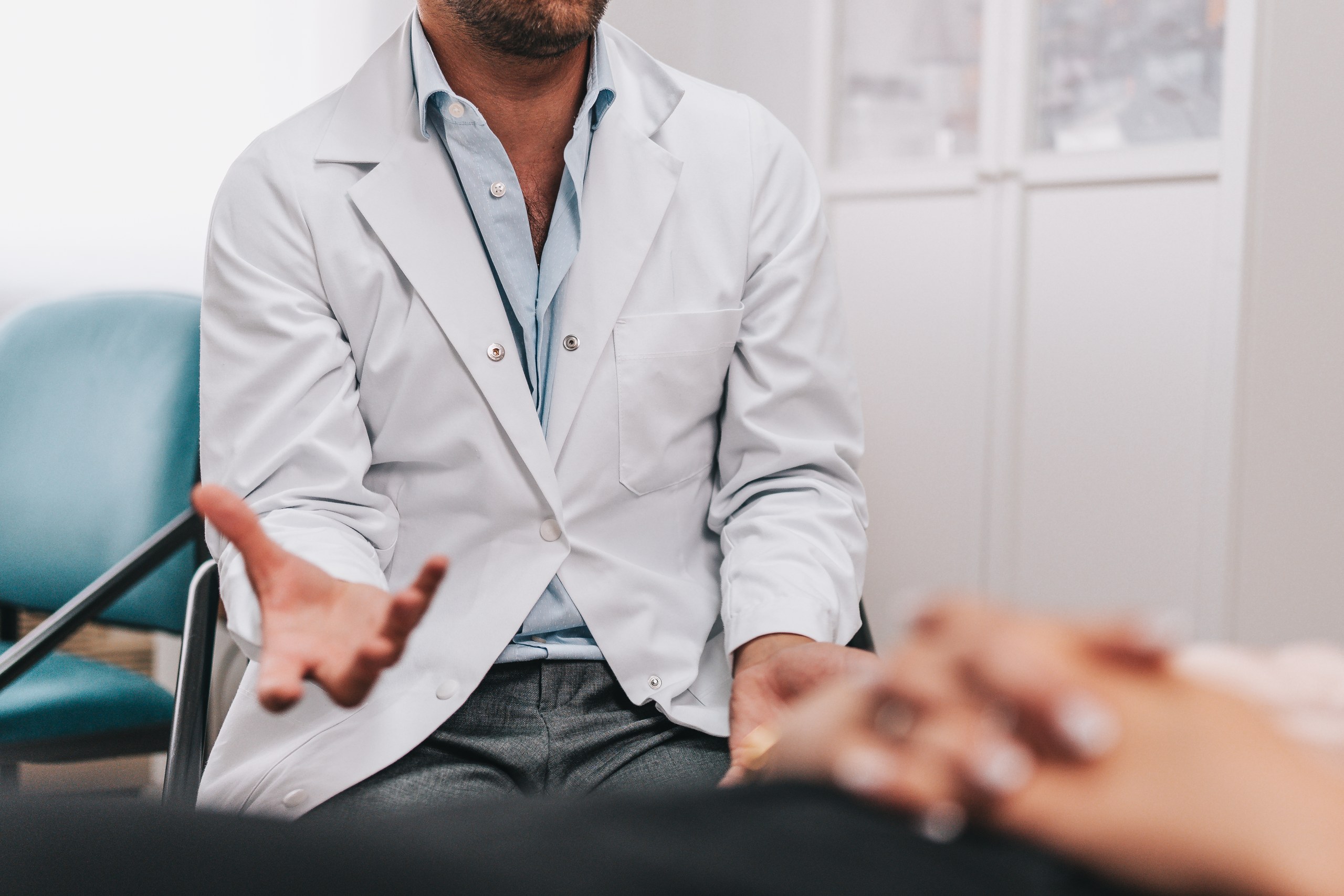 Médico em conversa com uma pessoa durante uma consulta